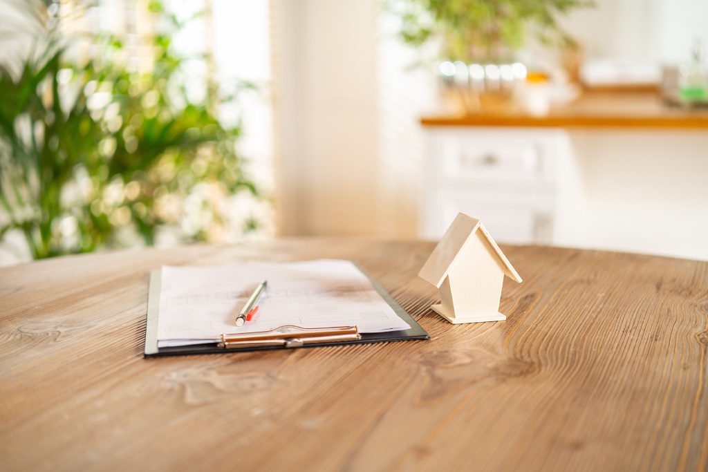 Clipboard and tiny wooden house
